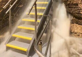 Stairway inside Niagara Cave surrounded by rushing floodwater after heavy rainfall