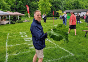 KTTC's Ted Schmidt throws a rhubarb stalk at the Rhubarb Festival in Lanesboro, MN
