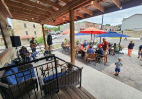Live music with people on the patio of Sylvan Brewing